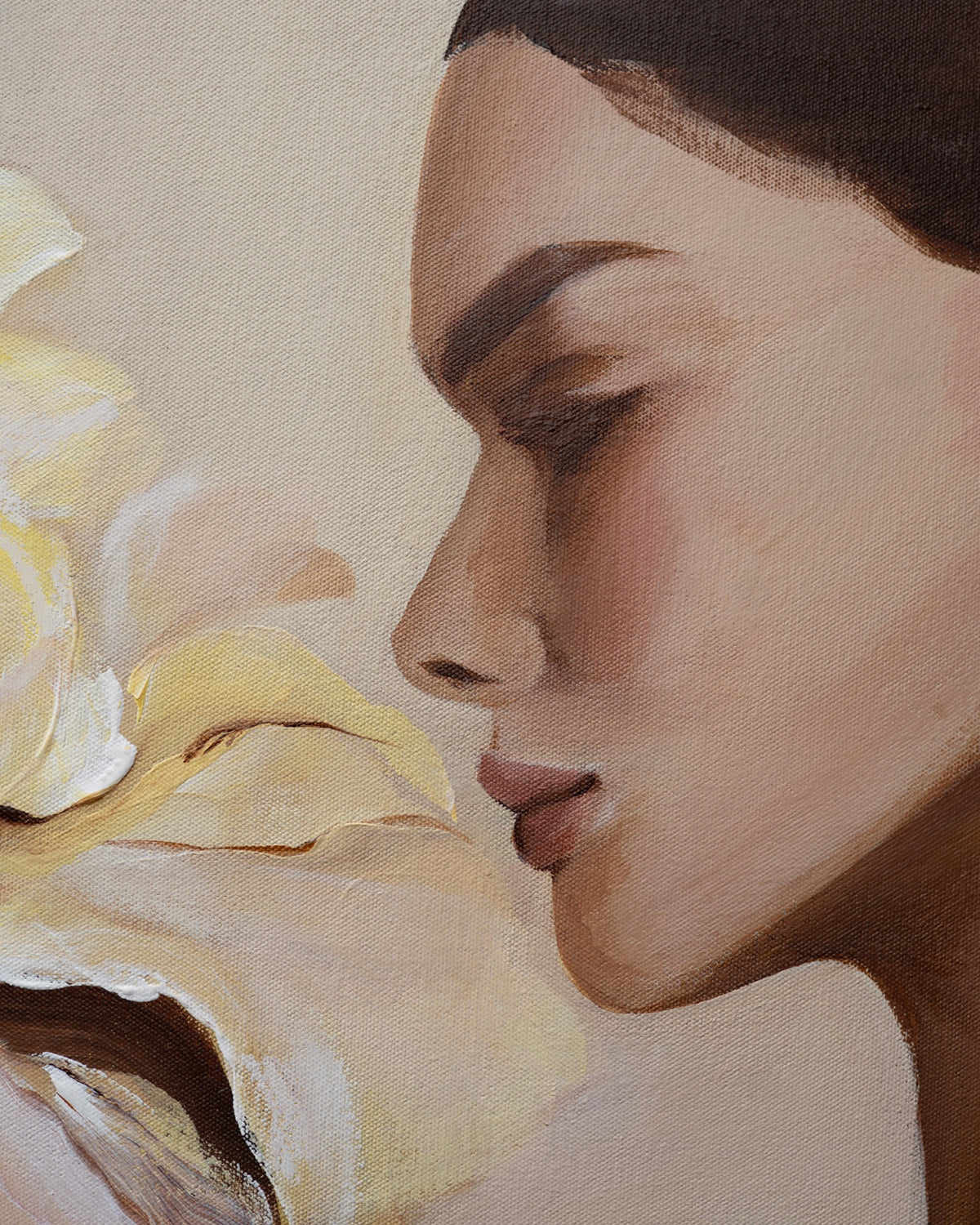 Close-up of the woman's face in Grace by Janka Kykalová, with a lowered gaze beside pale yellow iris petals.