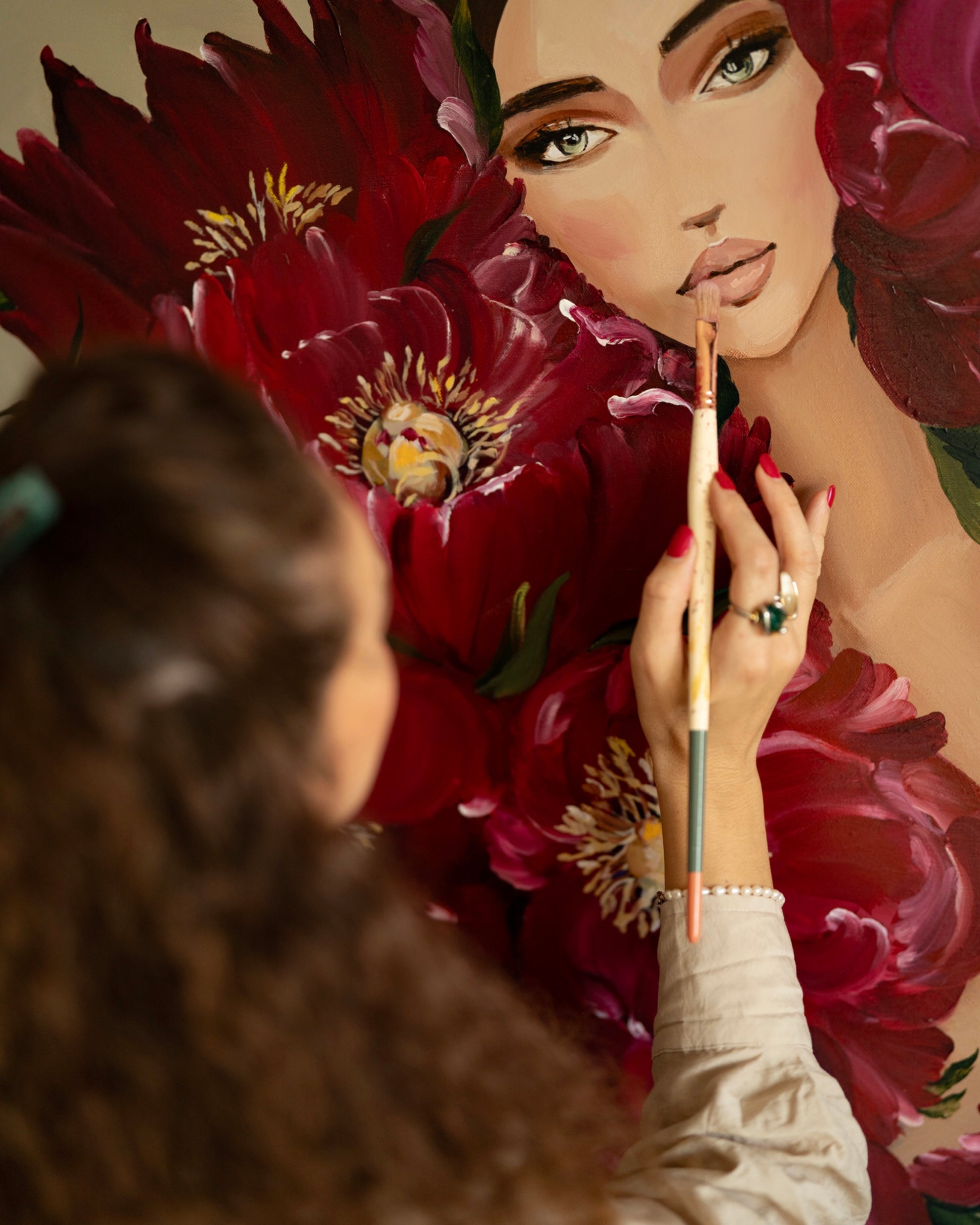 Artist Janka Kykalová painting the original artwork Karminová žena in her studio